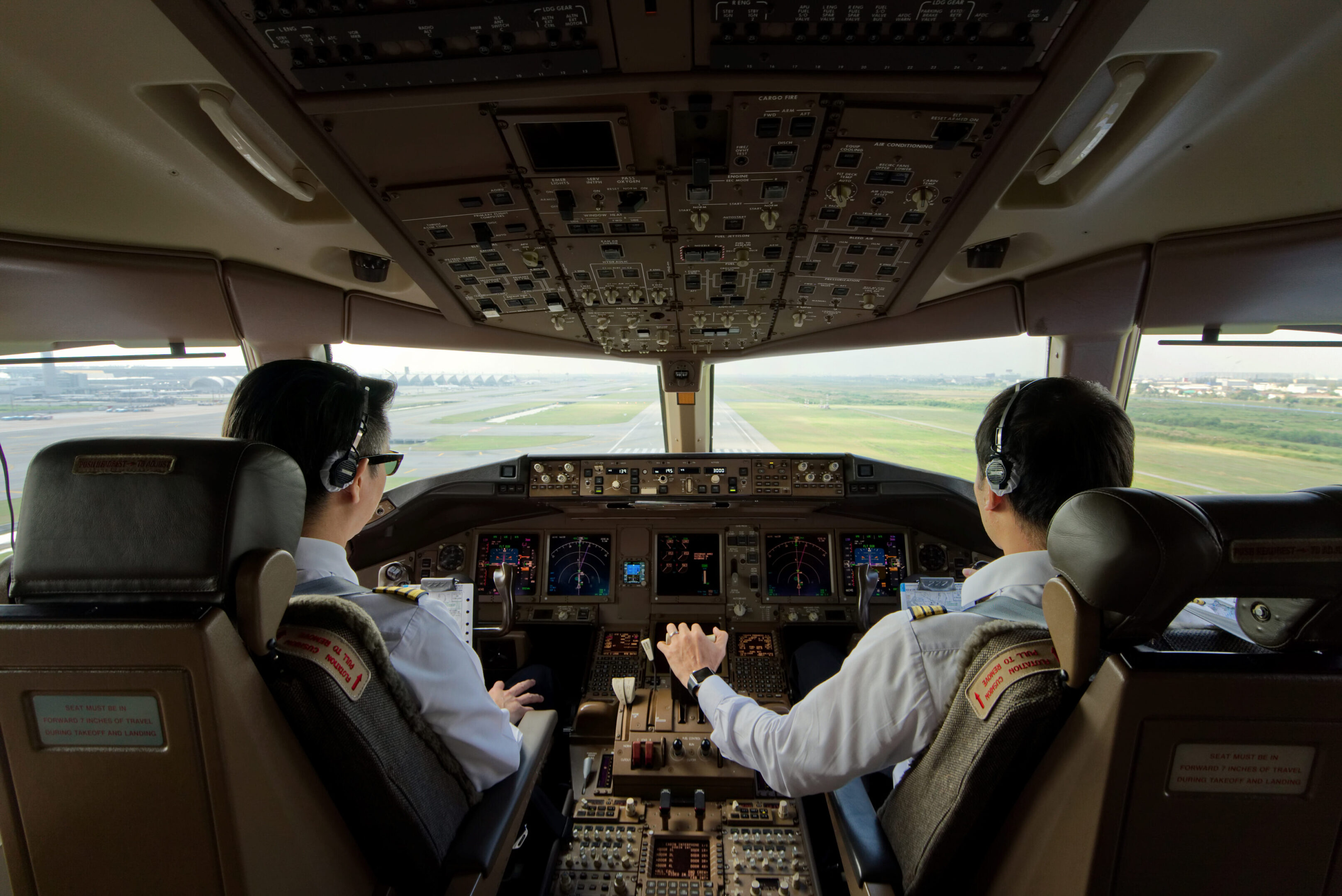 Two pilots are sitting in the cockpit of a plane.