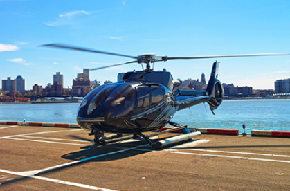 A helicopter is parked on the dock near water.